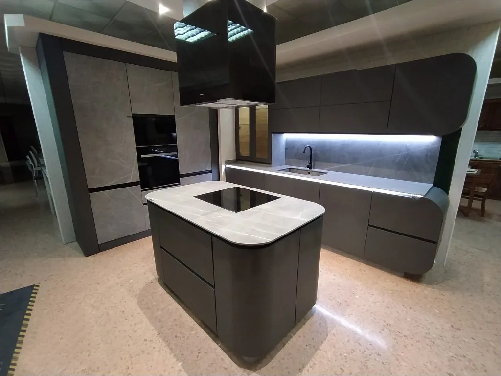 Cocina a medida con isla curva y frentes antracita en la exposición de Parreño Tébar en La Roda