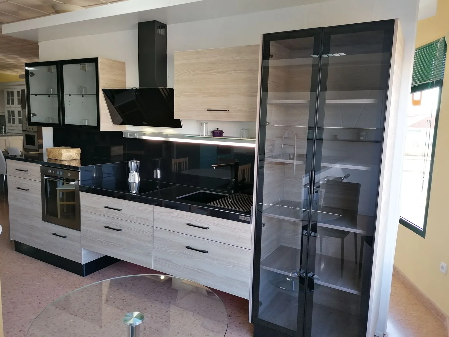 Cocina a medida con vitrinas de cristal y perfil negro